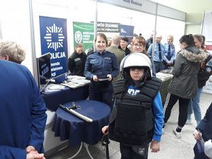 na fotografii około 10-letni chłopiec ubrany w umundurowanie służbowe policjanta zabezpieczającego mecze piłkarskie