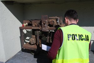 Policjant  prowadzi oględziny maszyny do rozdrabniania tytoniu