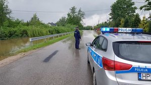 Policjanci zabezpieczają zalaną drogę