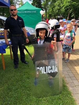 Chłopiec w umundurowaniu policyjnym, służącym do zabezpieczania imprez masowych.