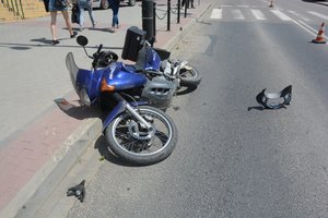 Na zdjęciu lezący niebieski motocykl. Pojazd, który brał udział w zdarzeniu drogowym z udziałem dzieci.