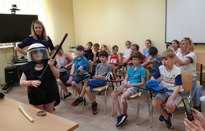 na fotografii dzieci wraz z policjantką w sali narad KPP Mielec