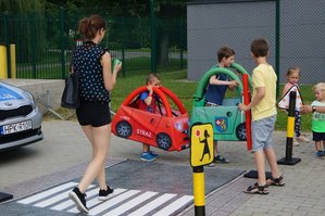 Dzieci uczą się przepisów ruchu drogowego korzystając z makiety autochodzik