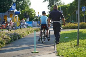 Policjant pomaga w nauce jazdy na rowerze.
