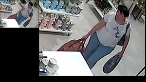 Na zdjęciu sprawczyni kradzieży  podchodzi do lady sklepowej.