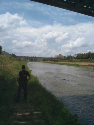Funkcjonariusz nad rzeką zabezpiecza miejsce zdarzenia