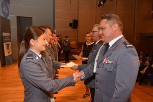 Na fotografii widać Komendanta Wojewódzkiego Policji który gratuluje policjantce awansu na wyższy stopień oraz Komendanta Powiatowego Policji który  gratuluje policjantom awansu.