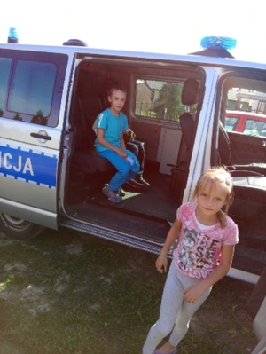 Na zdjęciu dzieci oglądające radiowóz.