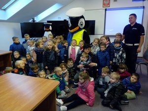 Grupa dzieci wraz z policjantem ruchu drogowego oraz policyjną maskotką- Pingwinem Stefanem.