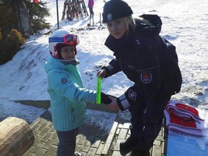 policjantka zakłada opaskę odblaskową dziewczynce