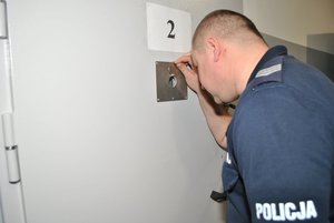 Policjant w pomieszczeniu dla osób zatrzymanych