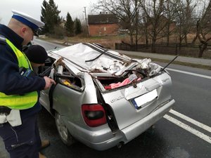 policjant robiący oględziny pojazdu, który brał udział w wypadku