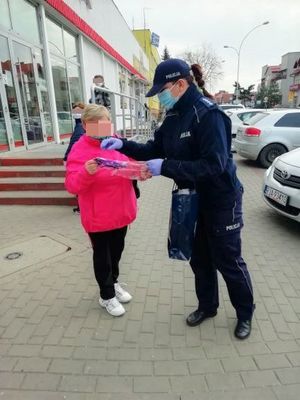 Policjanci podczas rozdawania maseczek ochronnych