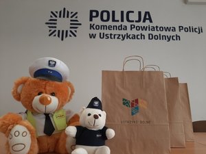 napis Komenda Powiatowa Policji w Ustrzykach Dolnych, maskotki policyjne, opakowania z maseczkami