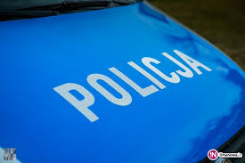 Zdjecie przedstawia pokrywe silnika radiowozu oznakowanego w kolorze niebieskim z białym napisem POLICJA