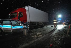 Zdjęcia z miejsca zdarzenia - noc, padający śnieg, uszkodzony radiowóz