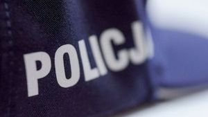 Zdjęcie przedstawia fragment mundury policyjnego (rękaw), na środku widnieje napis &quot;POLICJA&quot; w białym kolorze
