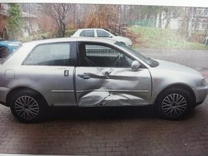 pojazd uszkodzony w zdarzeniu: srebrne audi z uszkodzonymi drzwiami i wybitą szybą
