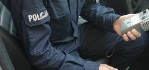 Na zdjęciu policjant, który trzyma urządzenie do badania stanu trzeźwości