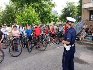 Policjantka Wydziału Ruchu Drogowego wraz z dziećmi uczestniczącymi w egzaminie na kartę rowerową.