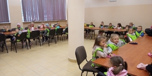 przedszkolaki siedzące w ławkach w trakcie spotkania