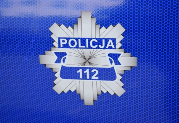 Odznaka policyjna na której widnieje napis Policja oraz numer 112