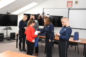 Policjanci wręczający nagrody laureatom konkursu.