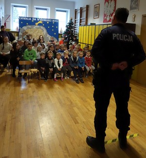 Policjant podczas prelekcji  z dziećmi dotycząca bezpiecznych ferii