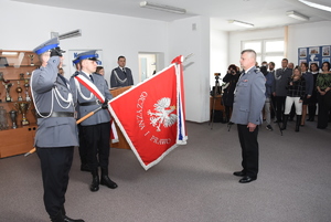 Komendant Łopuszański stoi na wprost pocztu sztandarowego i oddaje honor