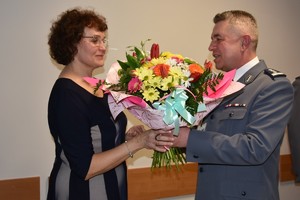 Komendant Powiatowy Policji w Ustrzykach Dolnych przyjmujący bukiet kwiatów