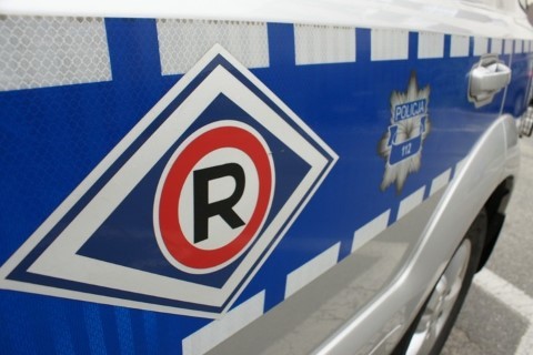 Na zdjęciu widoczne oznakowanie policyjnego radiowozu ruchu drogowego. Na drzwiach widnieje litera R obok dalej gwiazda policyjne i napis Policja.