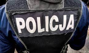 Na zdjęciu widoczny element umundurowania policjanta w postaci kamizelki, na której widnieje napis Policja.