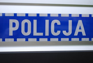 Na zdjęciu drzwi radiowozu z napisem policja.