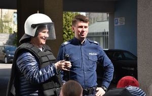 Opiekunka dzieci ubrana w policyjne wyposażenie ochronne wraz z policjantem