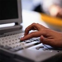 Na zdjęciu widać osobę, która wciska klawisze na komputerze.