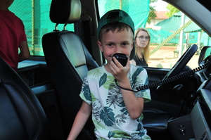Chłopiec w czapce mówiący do mikrofonu stacji radiowej