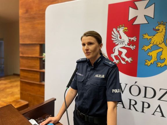 Na zdjęciu młodszy aspirant Anna Kurek z Komendy Miejskiej Policji w Rzeszowie. Policjantka stoi  przy mównicy.