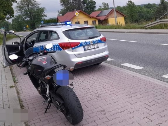 Na zdjęciu widoczny jest radiowóz oraz kontrolowany motocykl zatrzymany na przystanku autobusowym