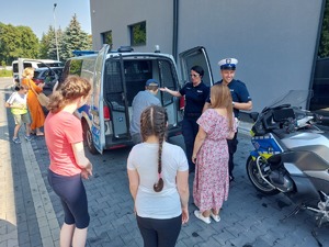 Policjanci prezentują radiowóz policyjny dzieciom