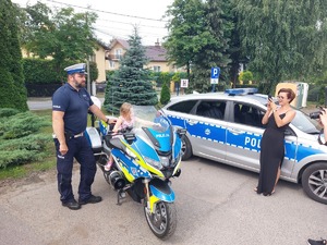 Policjant wraz z dzieckiem na motocyklu.