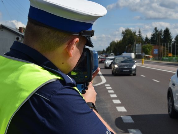 policjant ruchu drogowego z laserowym miernikiem prędkości
