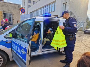 policjant podczas spotkania z dziećmi prezentuje radiowóz