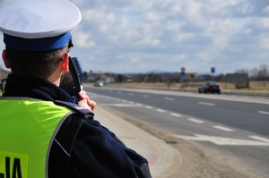 Policjant odwrócony plecami mierzący prędkość